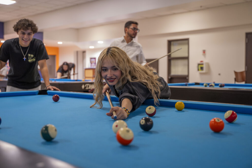 CSUF student plays pool during Titan Bowl and Billiards in the TSU