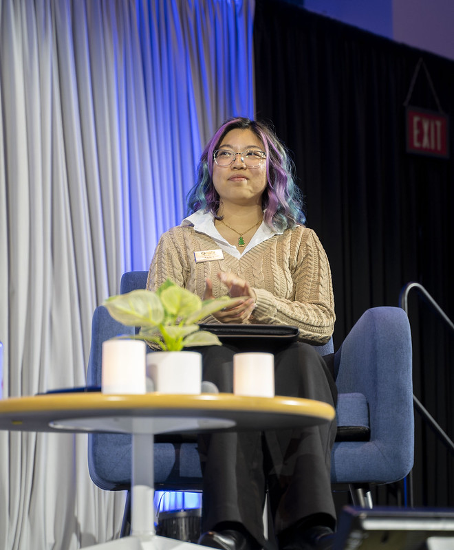 Kayla Lam, an ASI student programmer and moderator of the event, sitting on stage. 