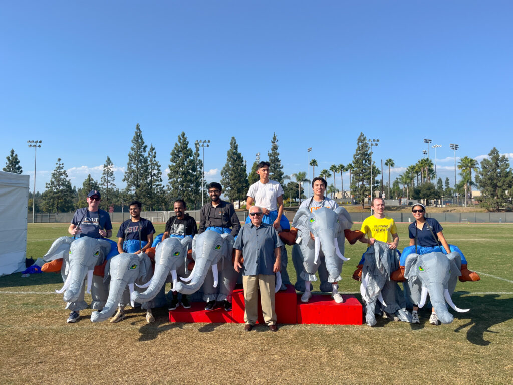 Elephant race winners pose for a picture with one another on a field