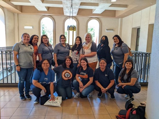 Lydia Palacios, with her staff from the Children's Center, posing together for a group photo.