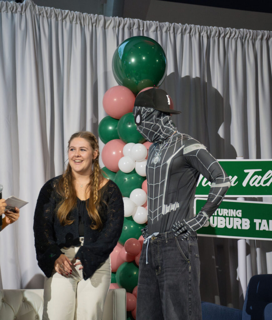 Titan Talk member dressed as spiderman interacts with a CSUF student