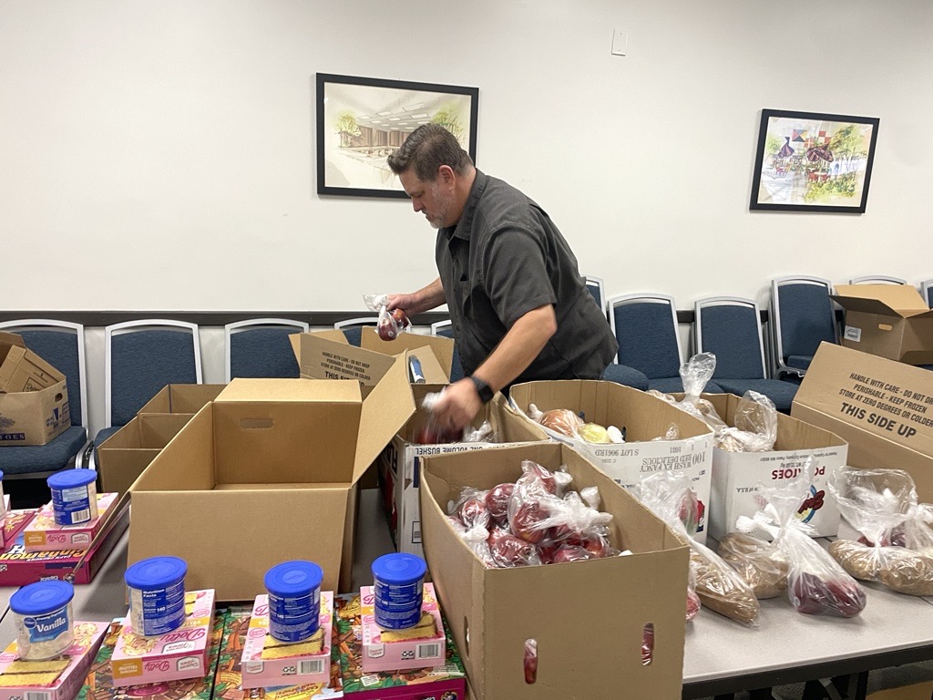 Man boxing items for food pantry event 