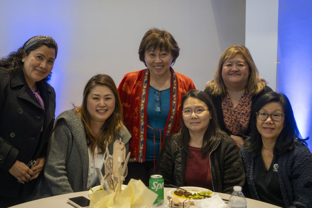 a group of people gathered around a table smiling