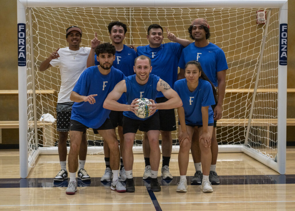 A group of people gather in front of a net.