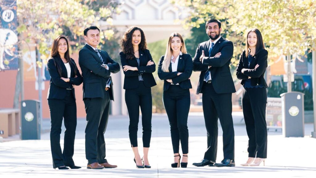 multi ethnic people dressed in suits standing posing for a picture