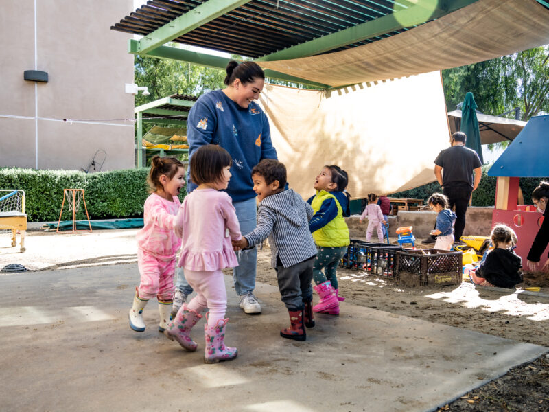 woman playing in a circle with children