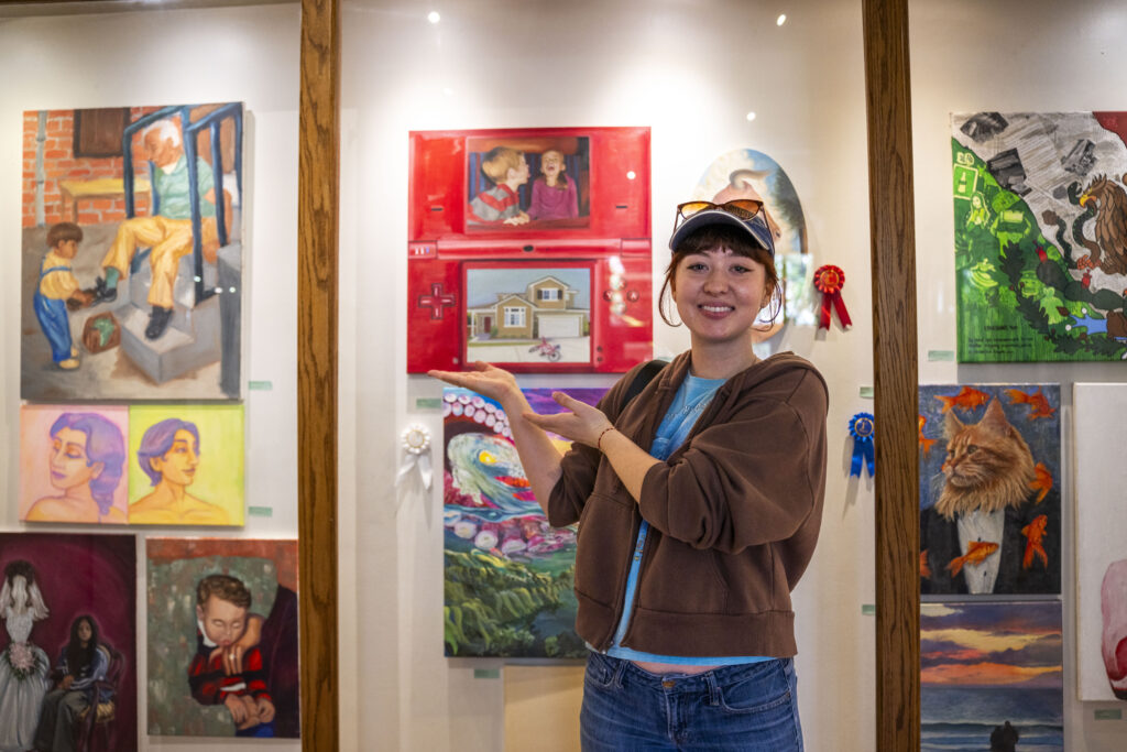 woman standing next to art wall