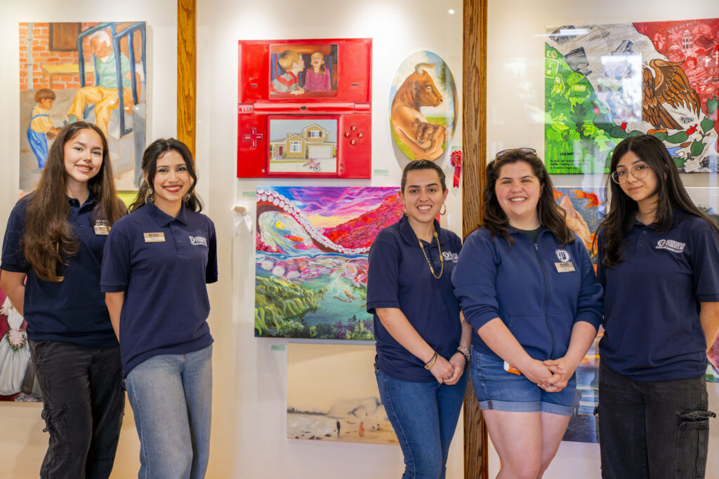 5 women standing in front of wall art