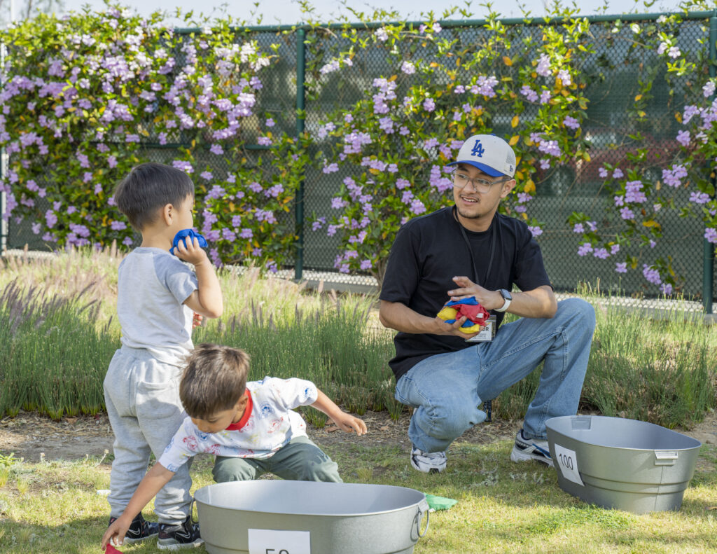 a young man with children playing a game outside