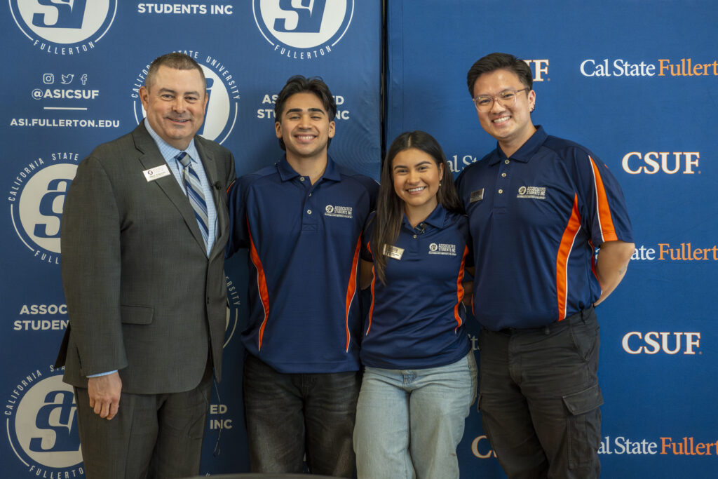A man standing with three young college students