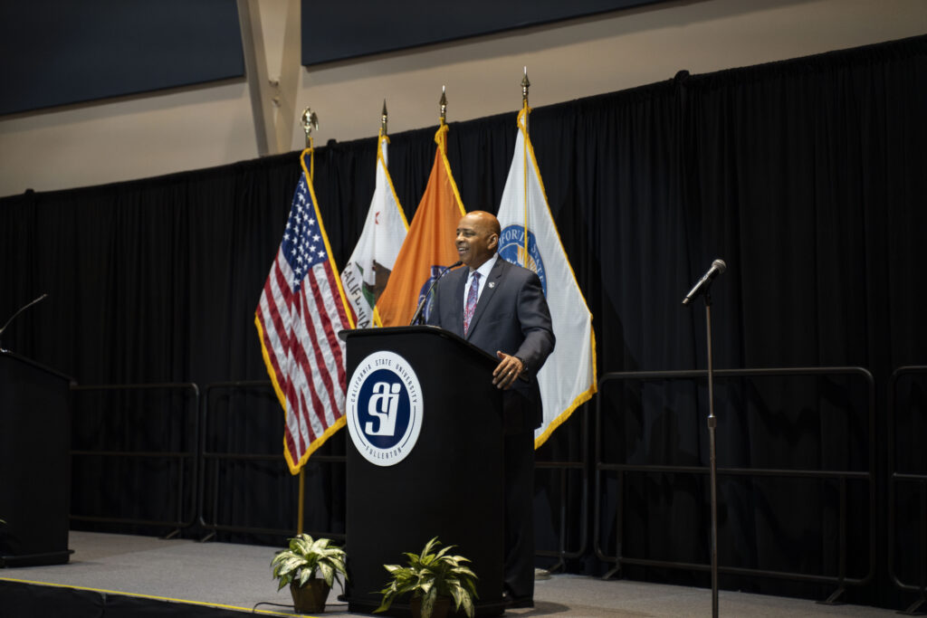 CSUF President Rochon speaking on a stage behind a podium