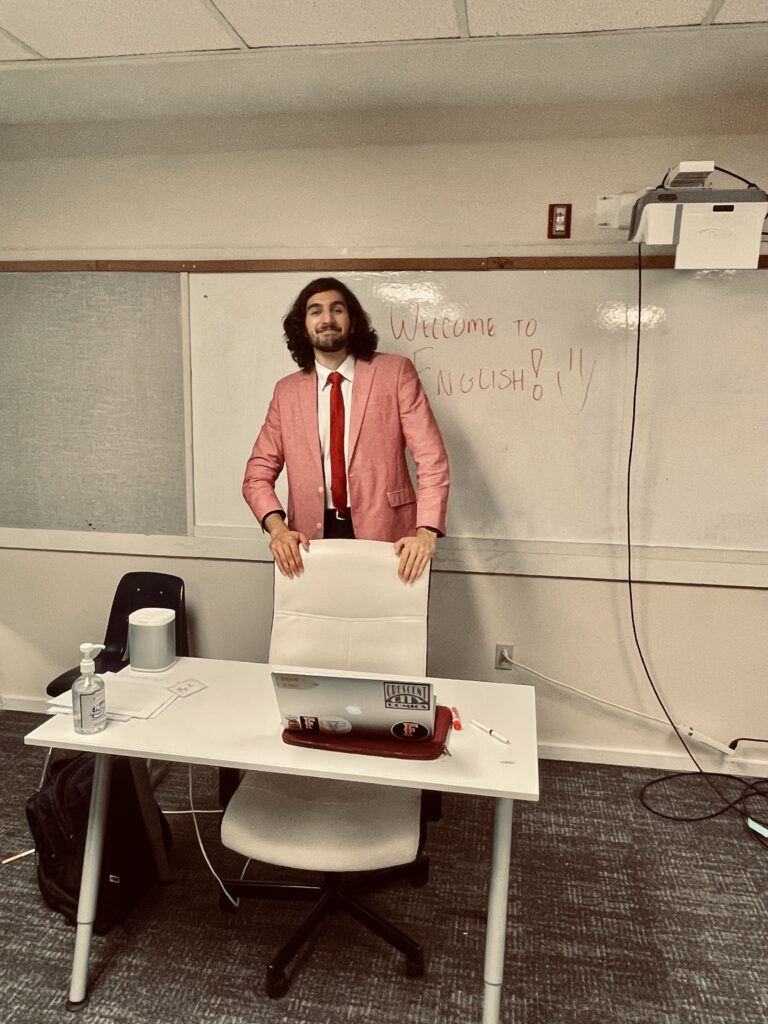 man standing behind a desk smiling
