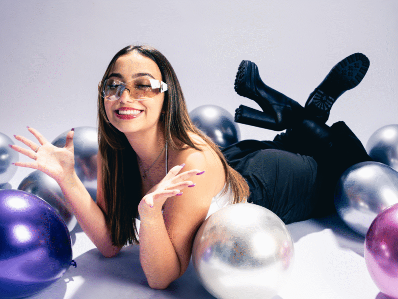 a young woman laying on the floor posing with balloons