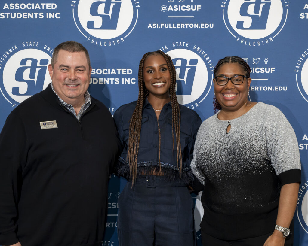 A man and a woman pose with Issa Rae