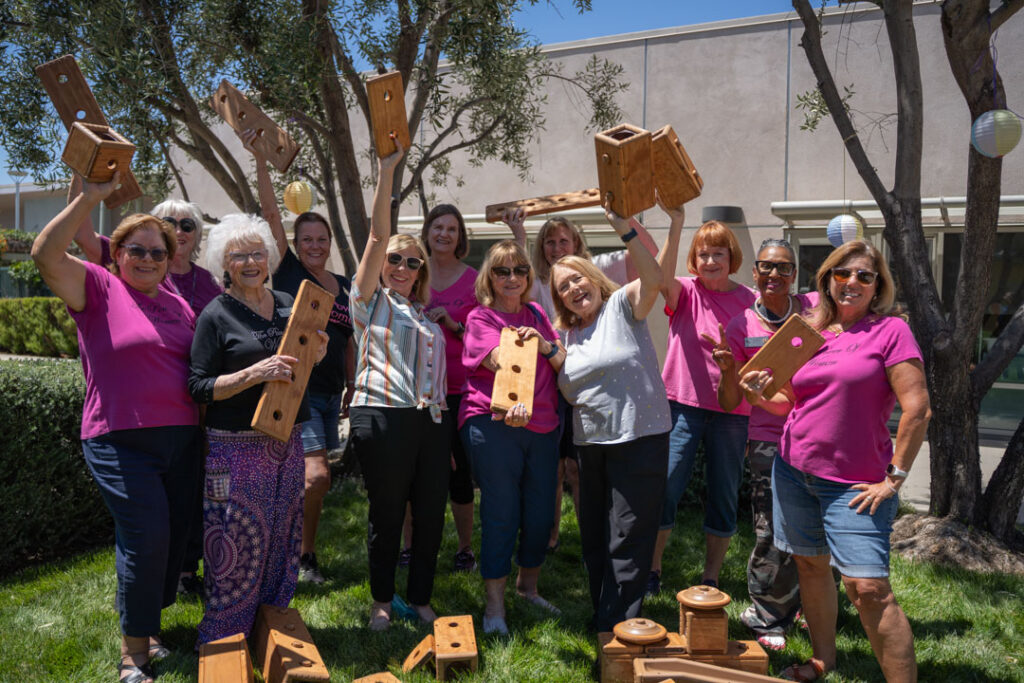 a group of women posing together for a picture holding wooden blocks