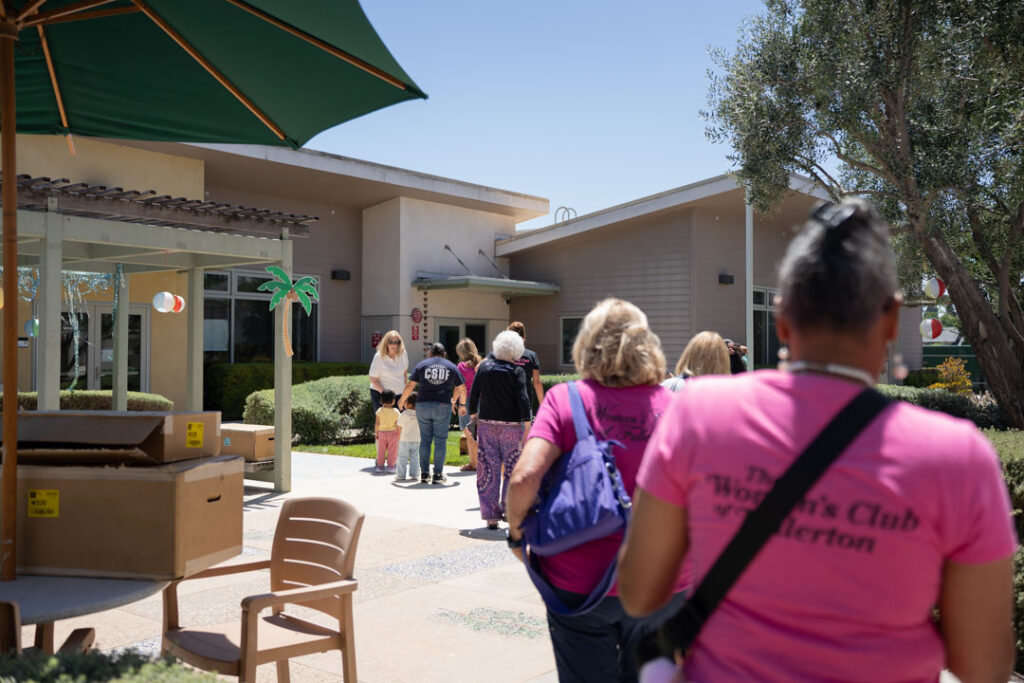 women in pink shirts walk to a building