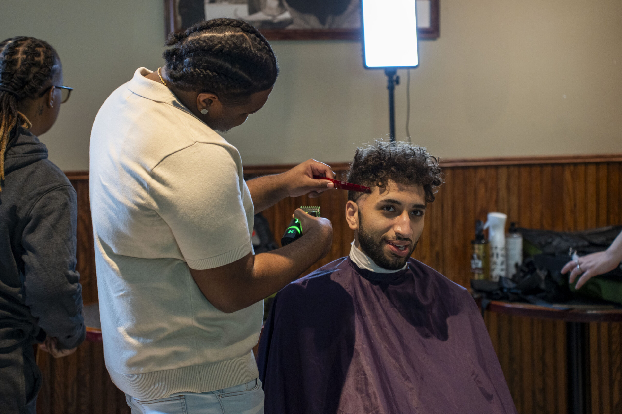 a young man gets a haircut in a barbershop setting