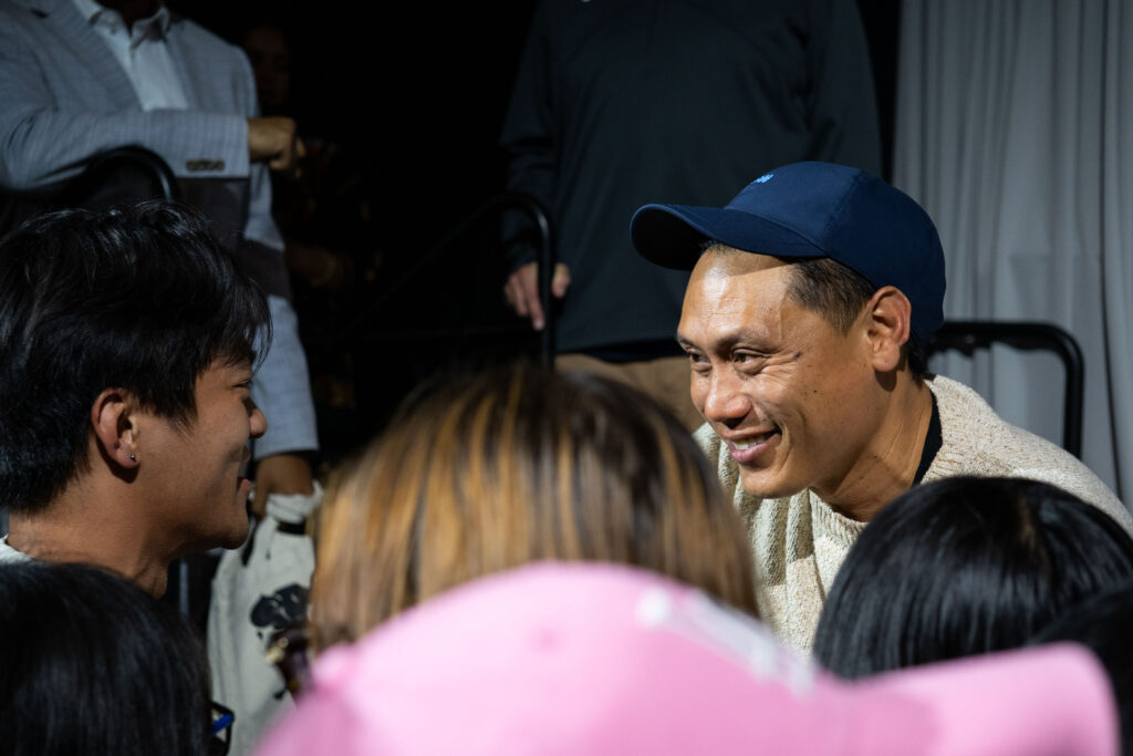 Jon M. Chu smiles at a student in the crowd.