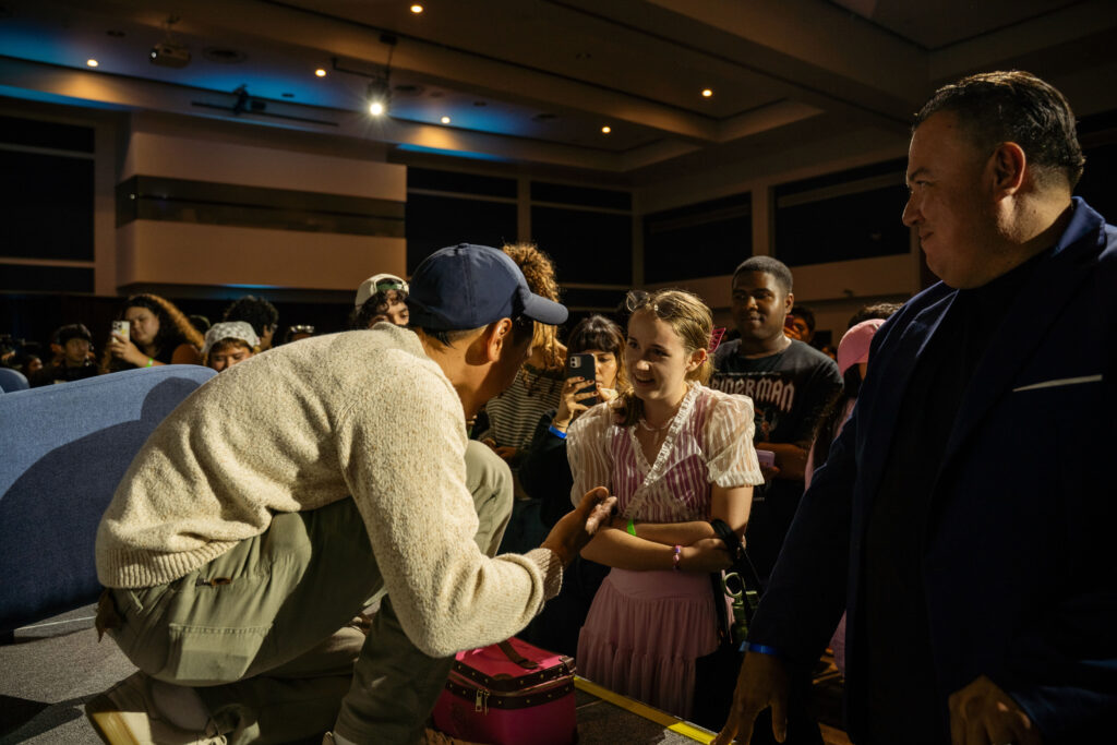 Jon M. Chu talks to a student in the crowd. 