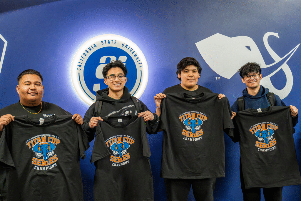a group of young men holding up black t-shirts