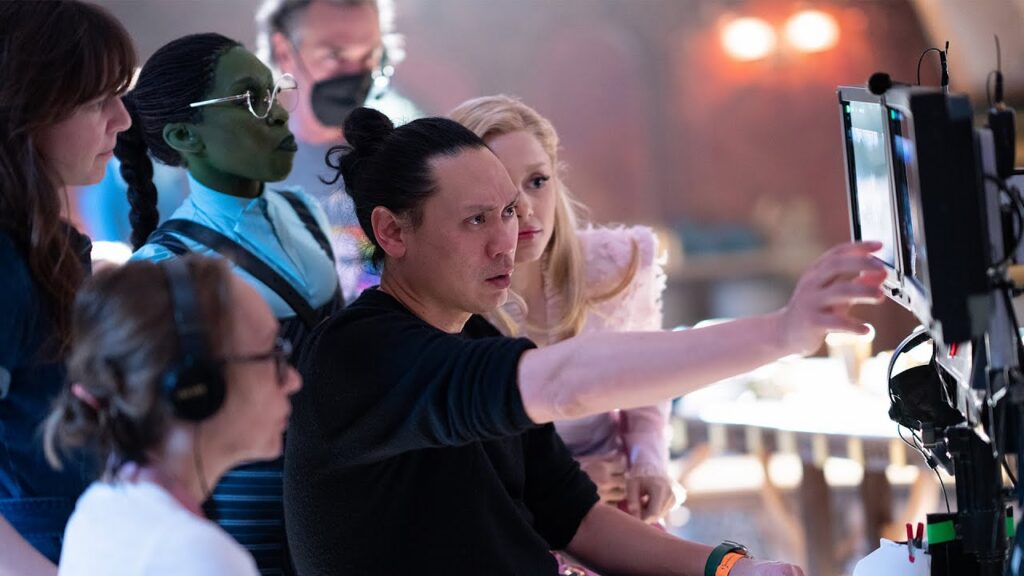 Jon M. Chu directs Ariana Grande and Cynthia Erivo on the set of "Wicked." 