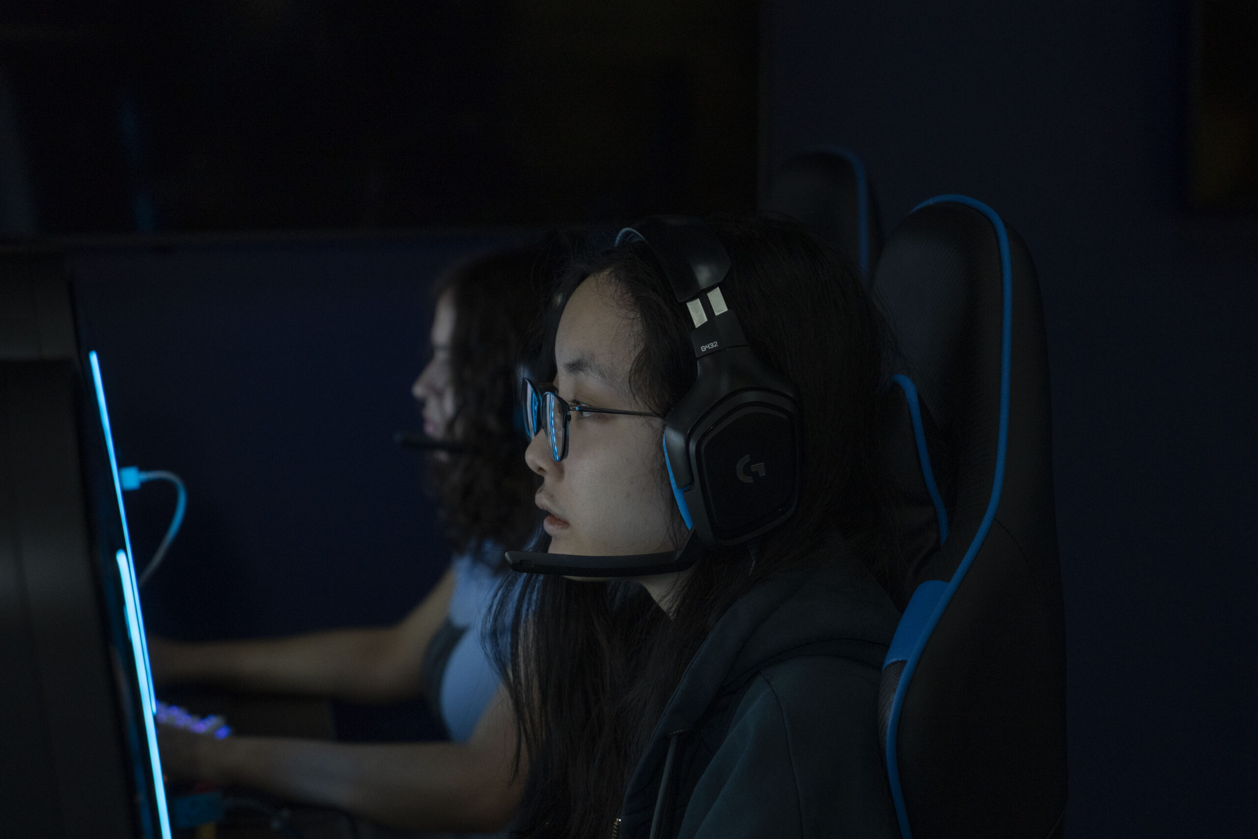 two girls gaming in front of computers