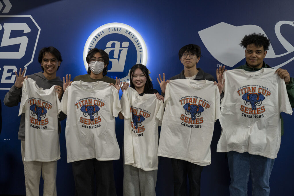 Picture with the 2024 Titan Cup: Valorant champions posing with their winner shirts. 