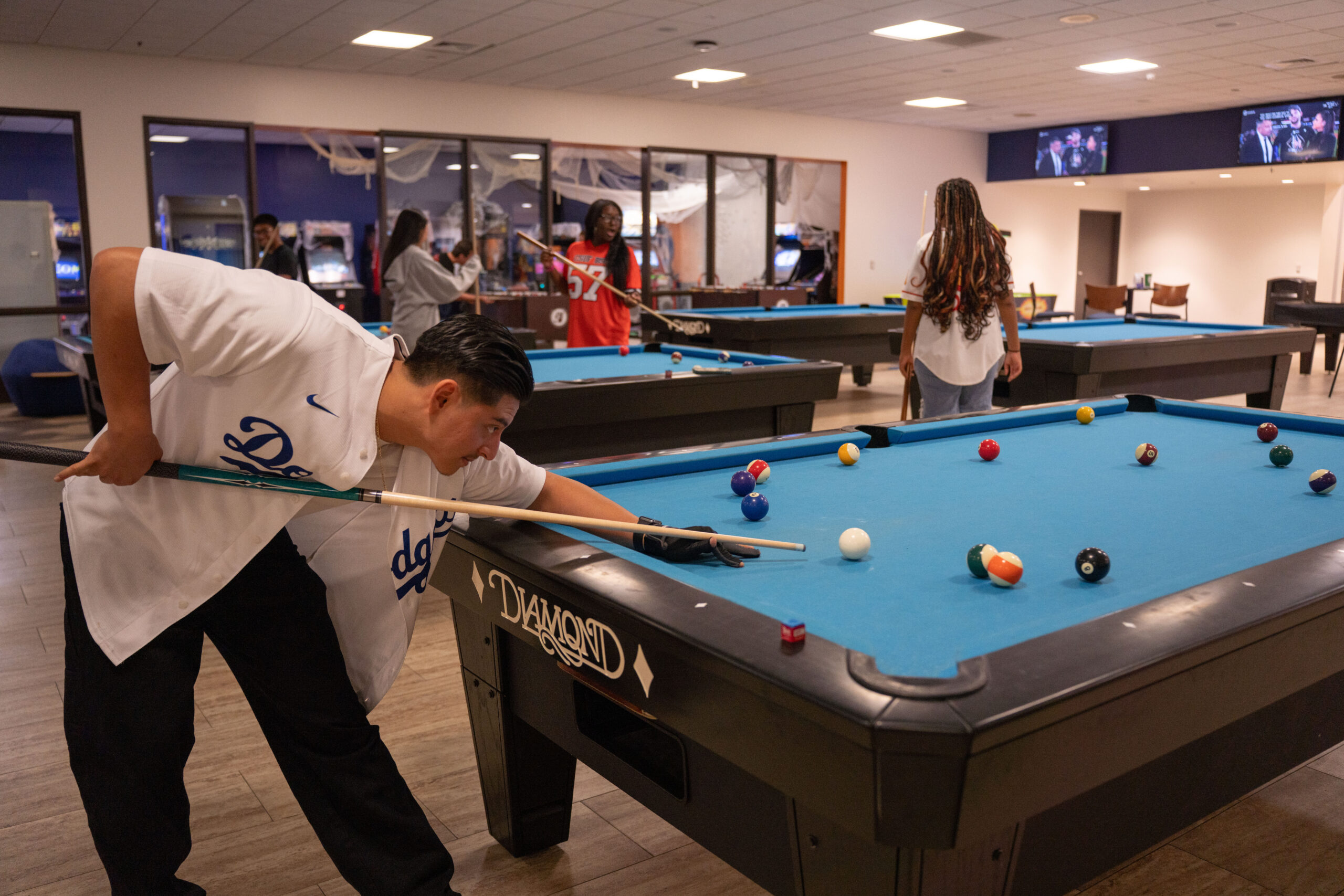 A man bending down to play a game of billiards.