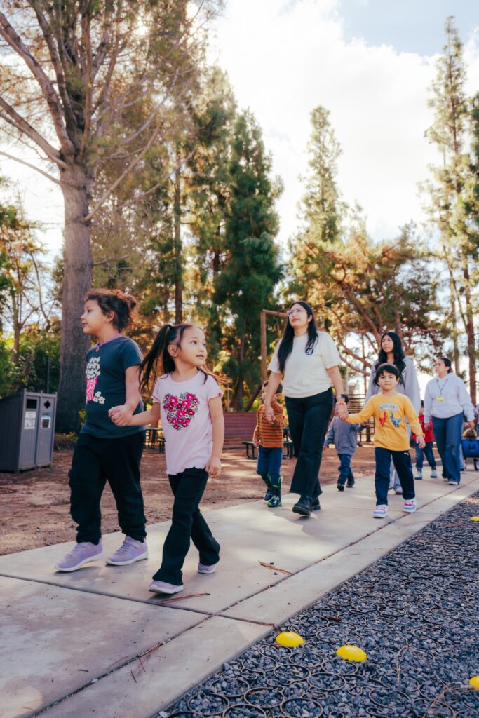 a group of students walk on a sidewalk