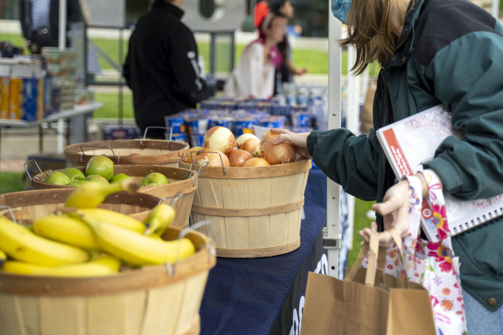 a hand grabs an onion from a basket 
