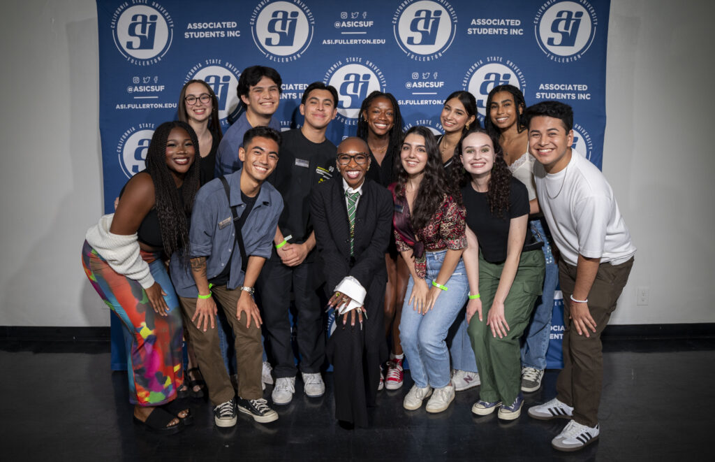 a group of college students pose for a group picture with Cynthia Erivo