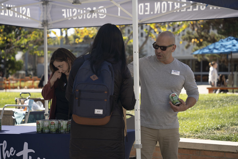 ASI Staff Member hands out food to student during pop-up pantry