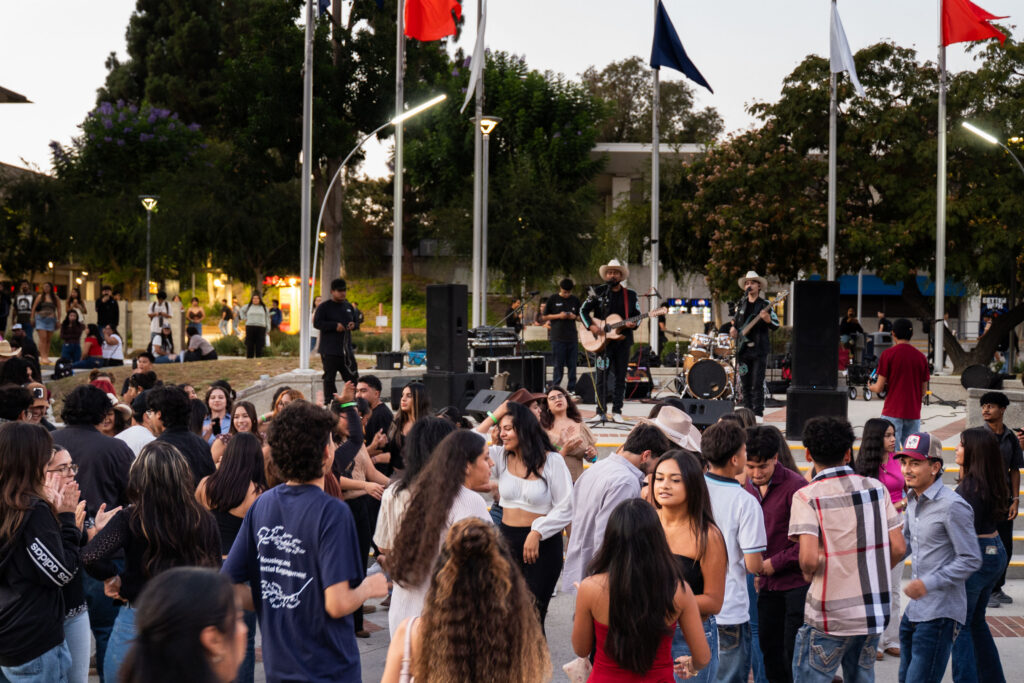 a group of dancers and people dance in a college quad area