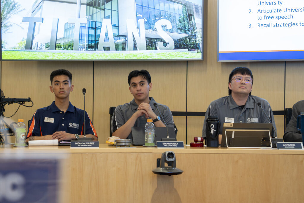 three college students sitting in a board meeting