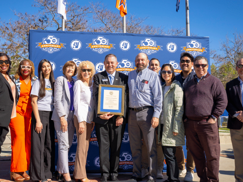 a group of professionals pose against a blue backdrop