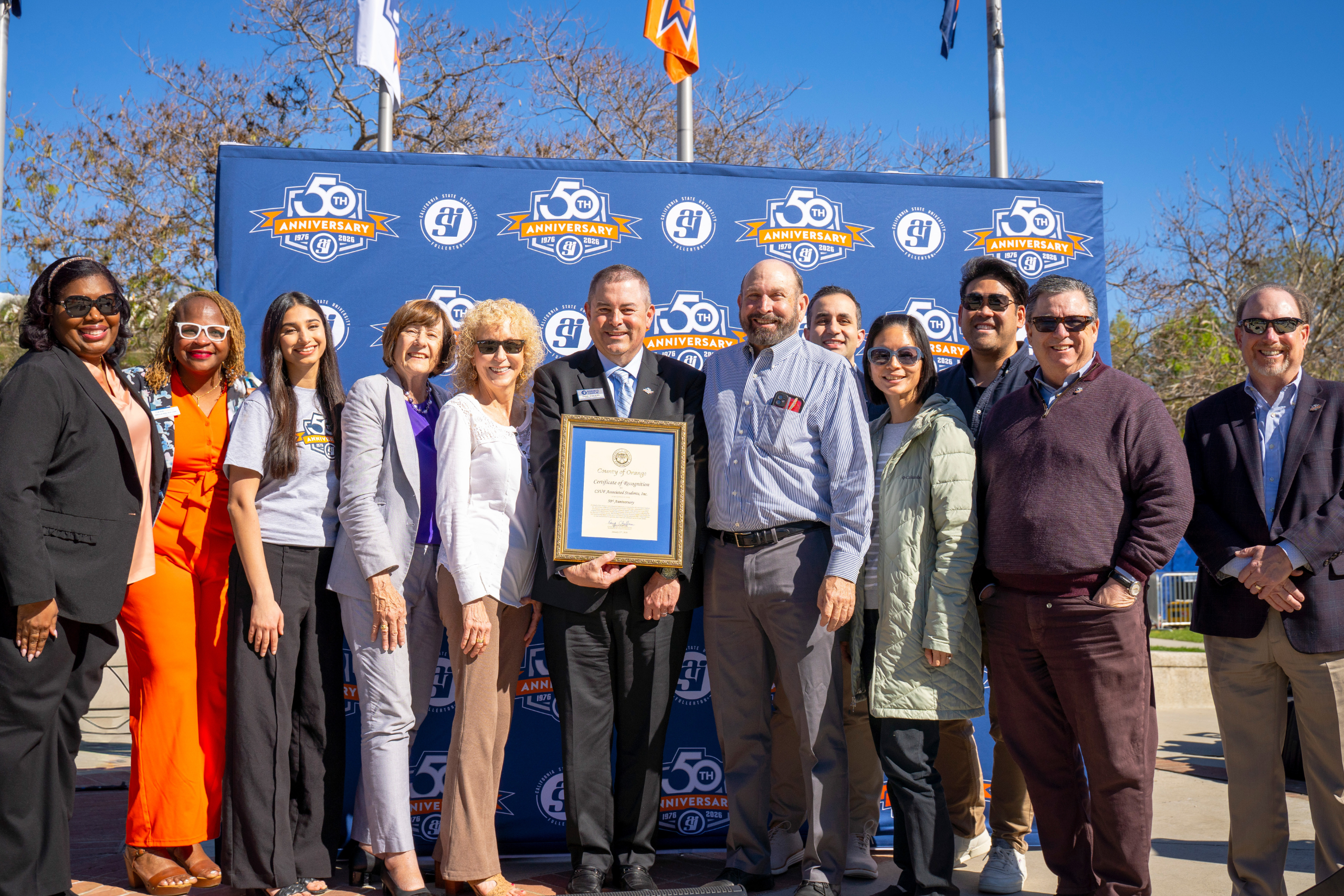 a group of professionals pose against a blue backdrop
