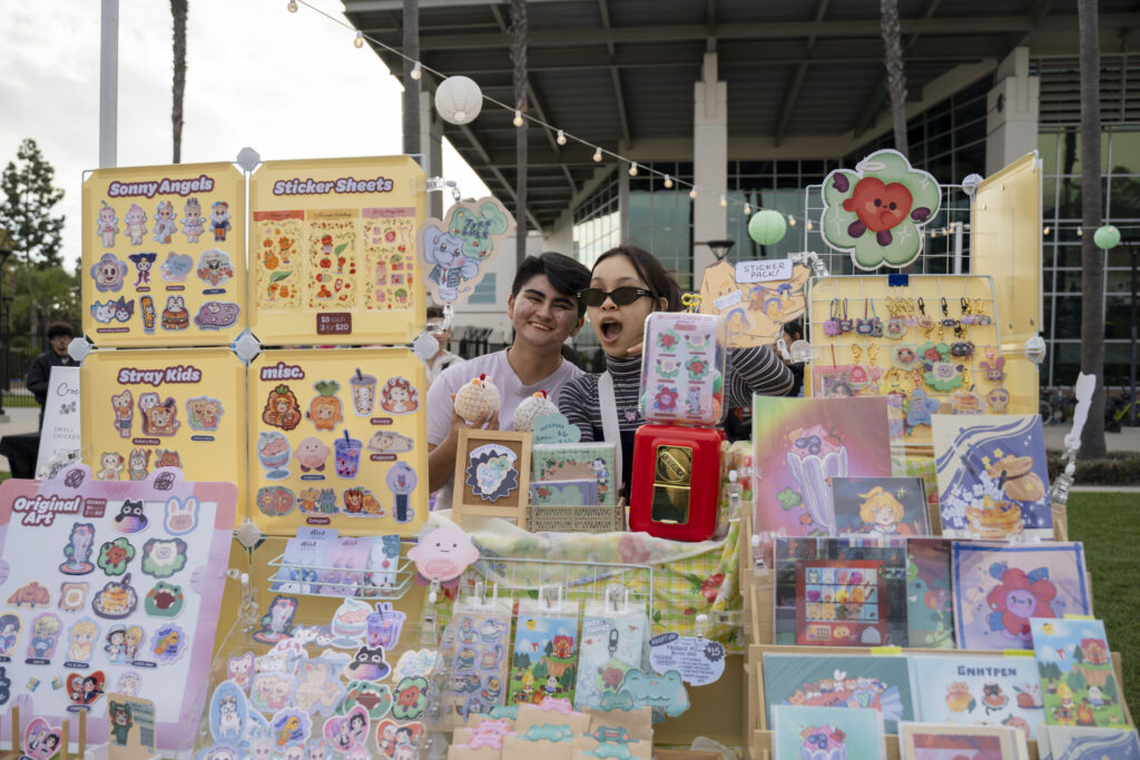 two students at an art booth pose for a picture