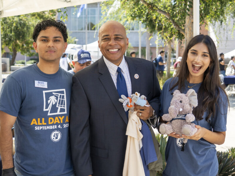 college students and a man in a suit pose for a picture together