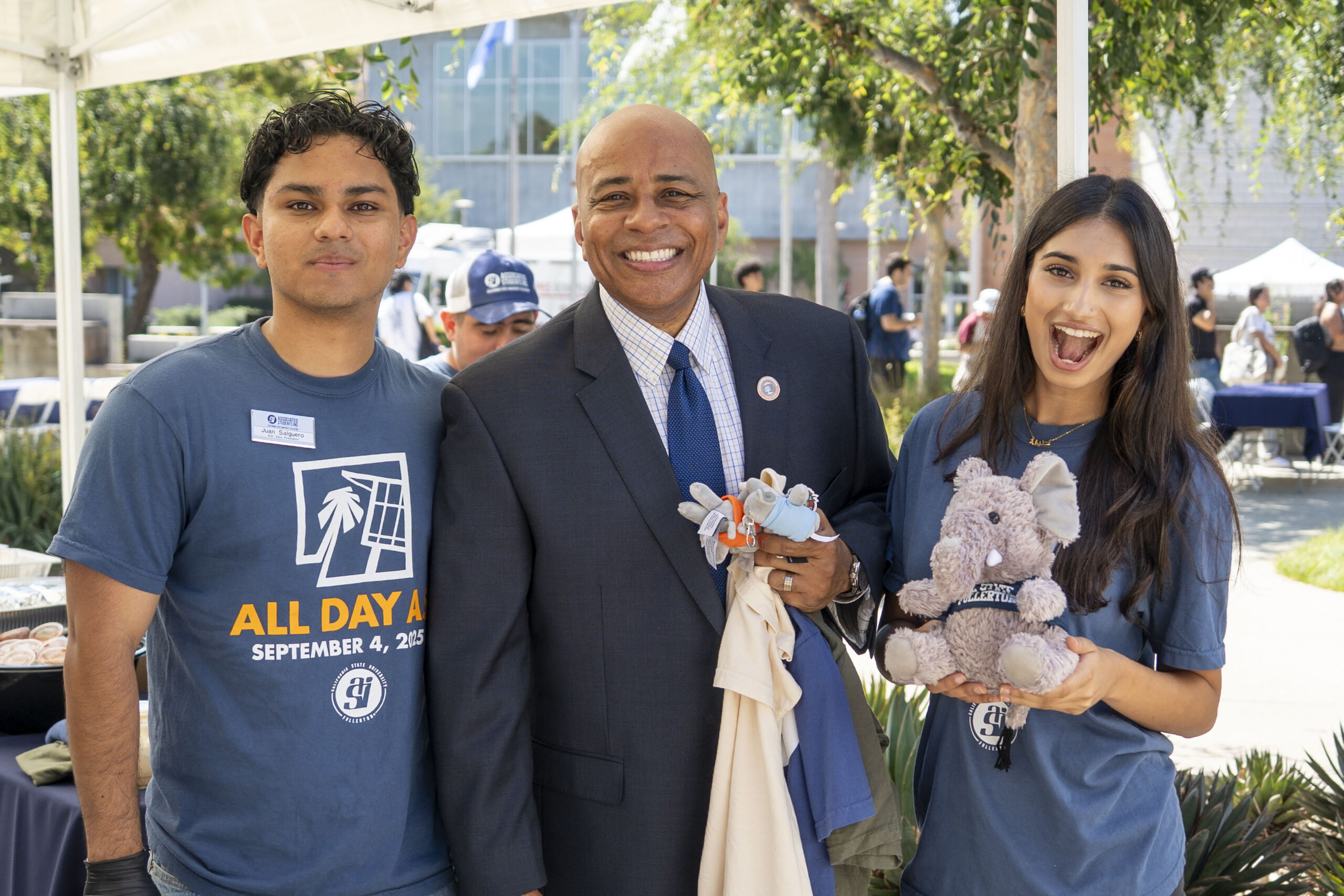 college students and a man in a suit pose for a picture together