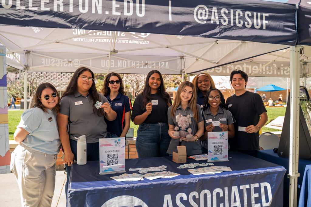 a group of college student spsoe for a picture under a canopy