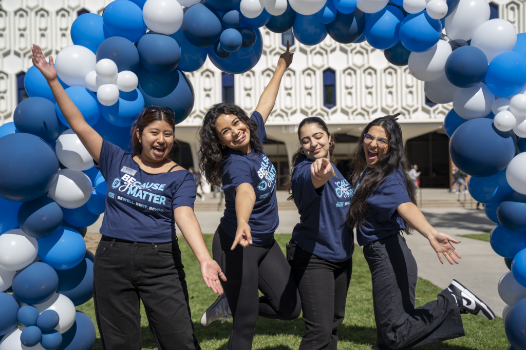 a group of girls cheering and posing outside