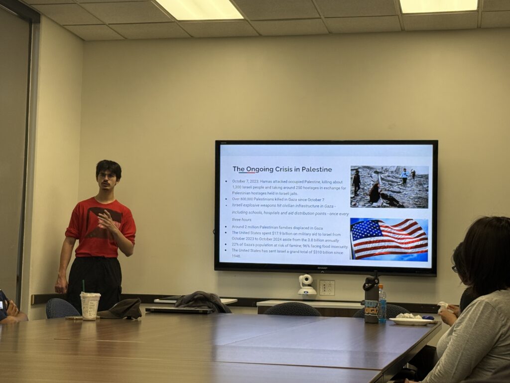 a young man presenting in front a screen 