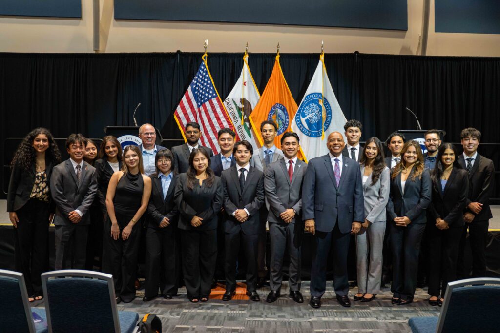 a group of students in suits posing with campus leaders 