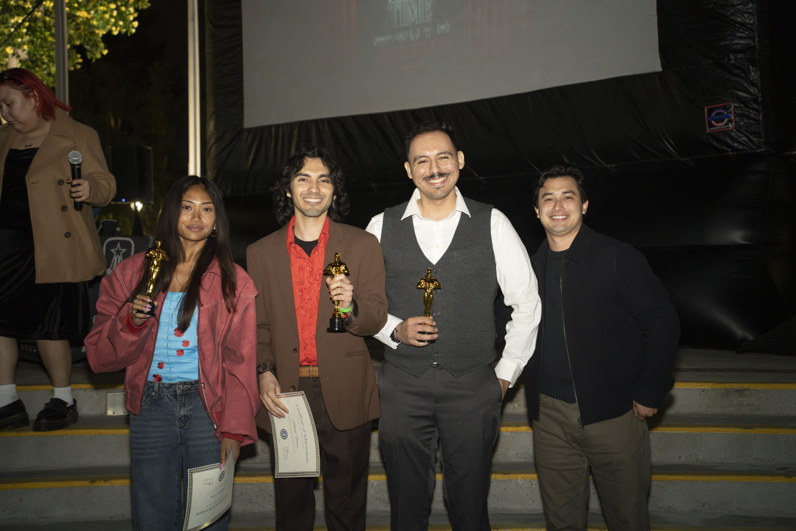 a group of students pose together holding trophies