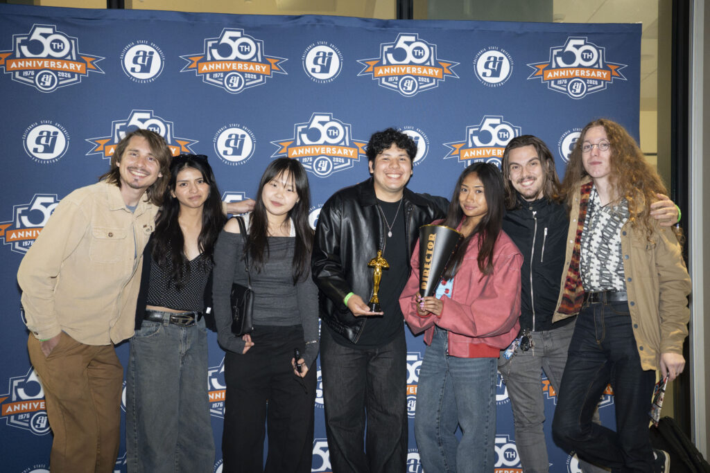 a group of students pose for a picture in front of a blue backdrop 