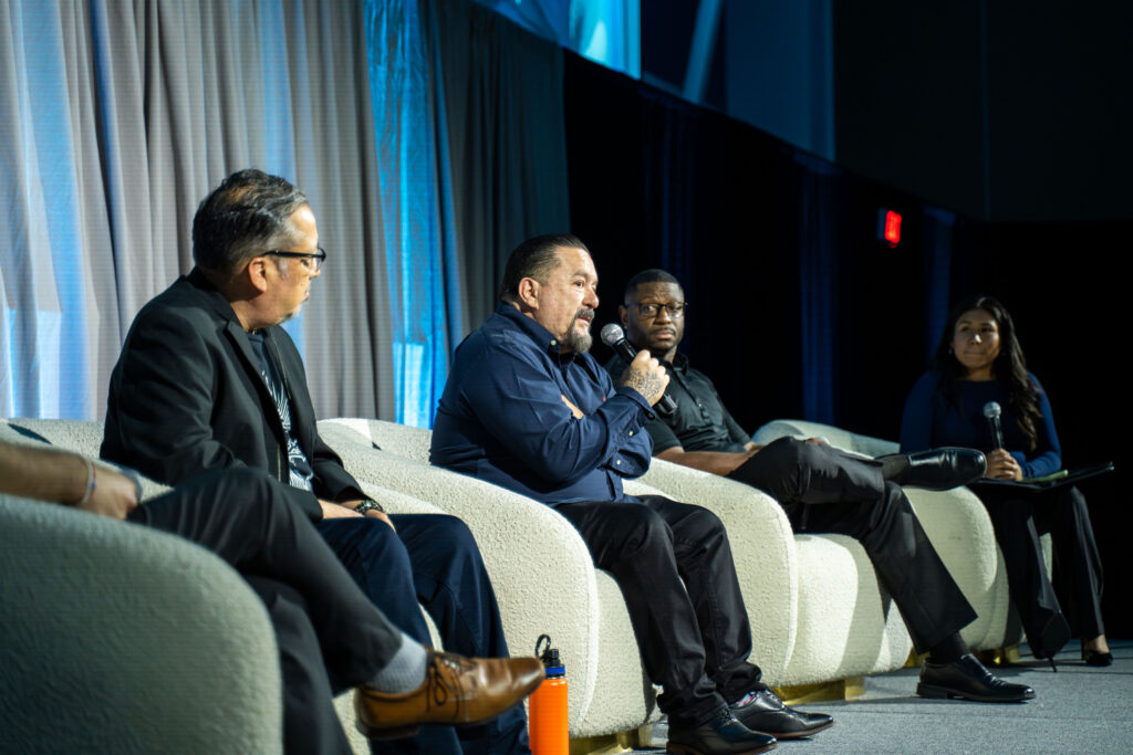 Mr.Cartoon alongside a giant panel of people