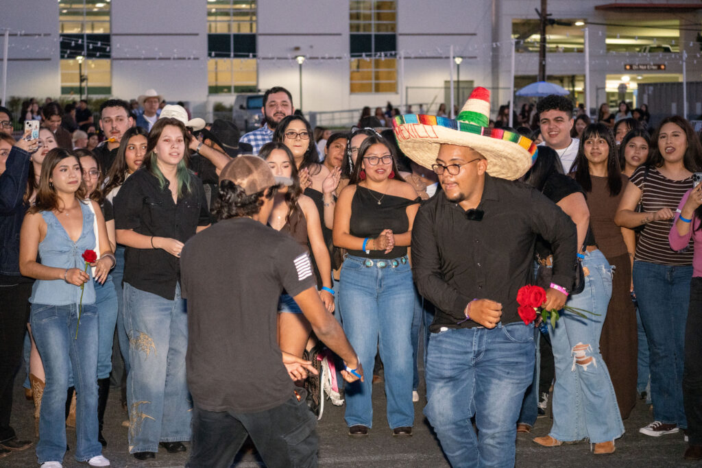 two hispanic young men dance in a circle 