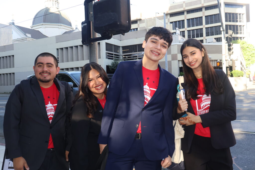 a group of smling college students in red shirts pose for a picture 