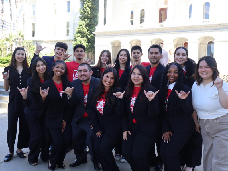 a group of students in black sweater pose for a group picture