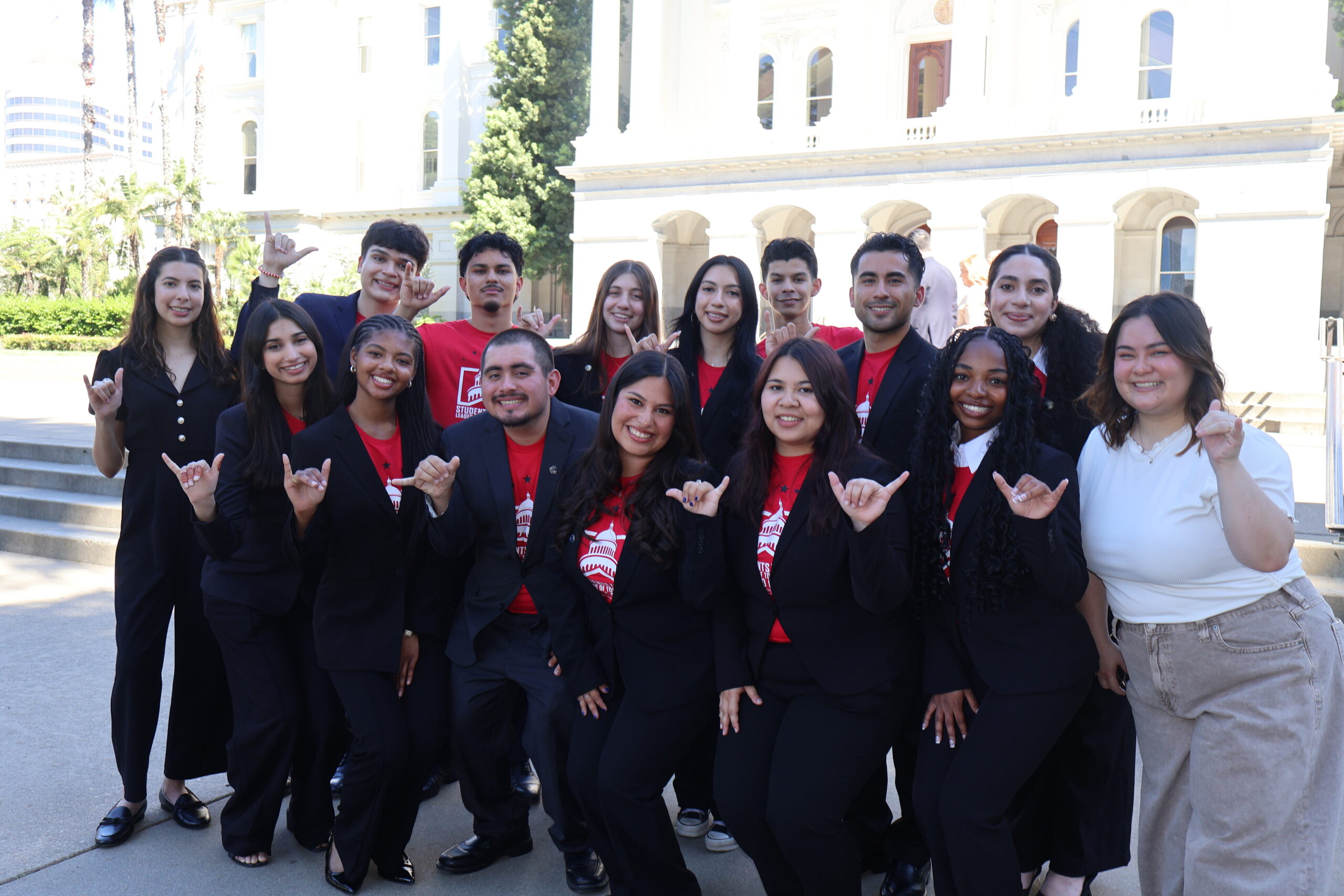 a group of students in black sweater pose for a group picture